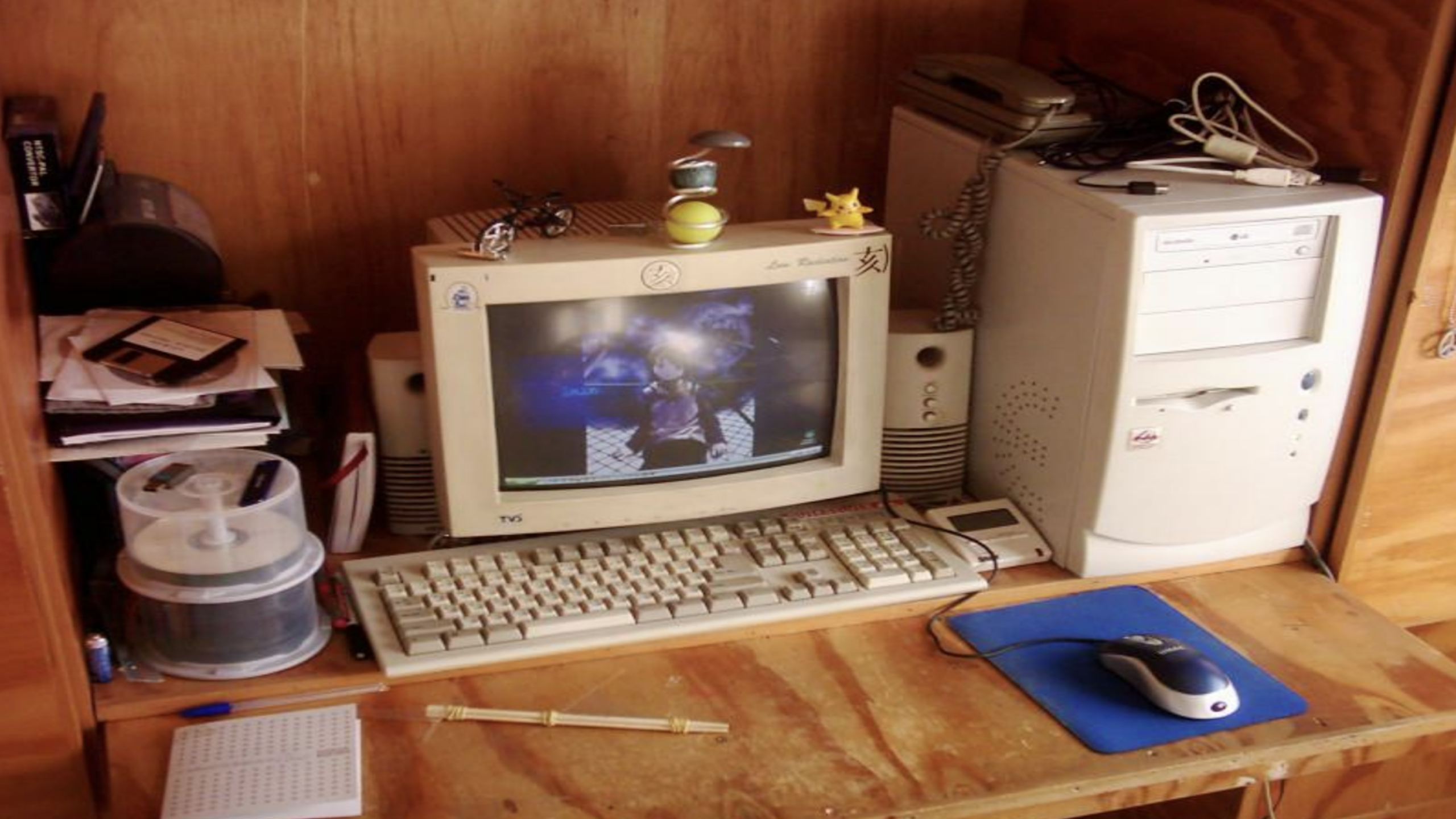 vintage beige desktop setup with CRT monitor wired mouse speakers wooden desk early 2000s