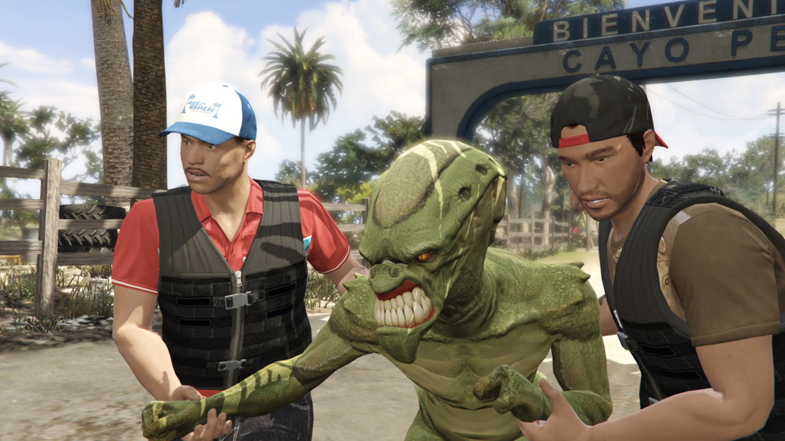 Two men in vests and hats stand on either side of a snarling green alien creature outdoors, near a sign that reads "Bienvenidos Cayo Perico," with palm trees in the background—creating a scene reminiscent of an action-packed moment from a video game.
