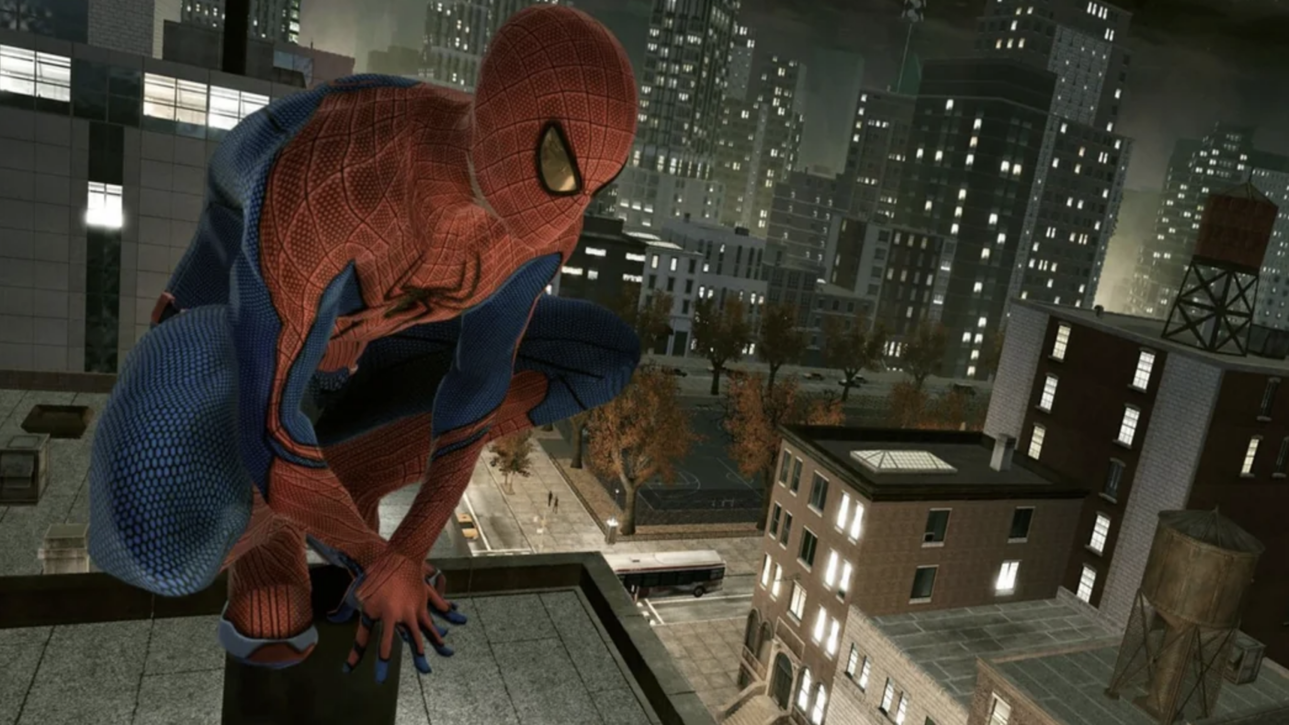 Spider-Man crouches on the edge of a rooftop at night, his silhouette framed against a cityscape with tall buildings, glowing windows, and trees adorned with autumn leaves.
