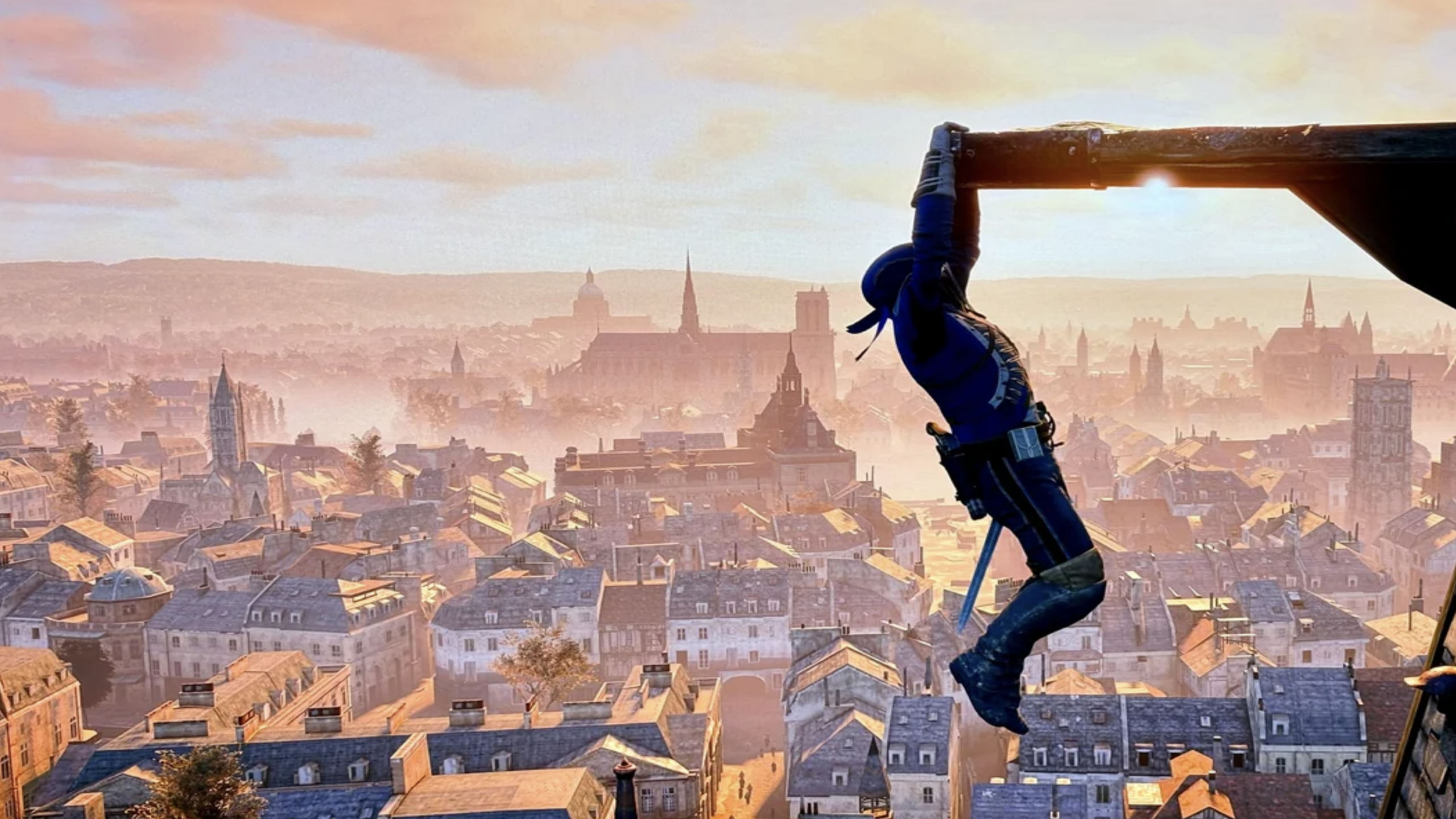 A person in dark clothing and a hood hangs from a wooden beam high above a city with many old, closely packed buildings under a colorful sky at sunset, evoking the mysterious presence of Spider-Man as he surveys the world below.