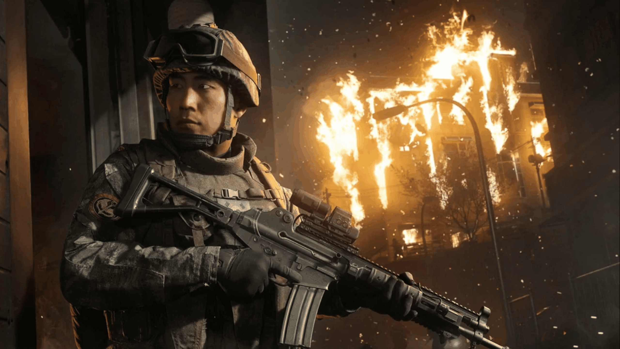 A soldier in tactical gear holds a rifle, looking alert. Behind him, a building is engulfed in flames at night, with debris in the air—a scene straight out of GTA 6. The atmosphere is tense and dramatic, suggesting a high-stakes combat or emergency situation reminiscent of the game’s intense moments.