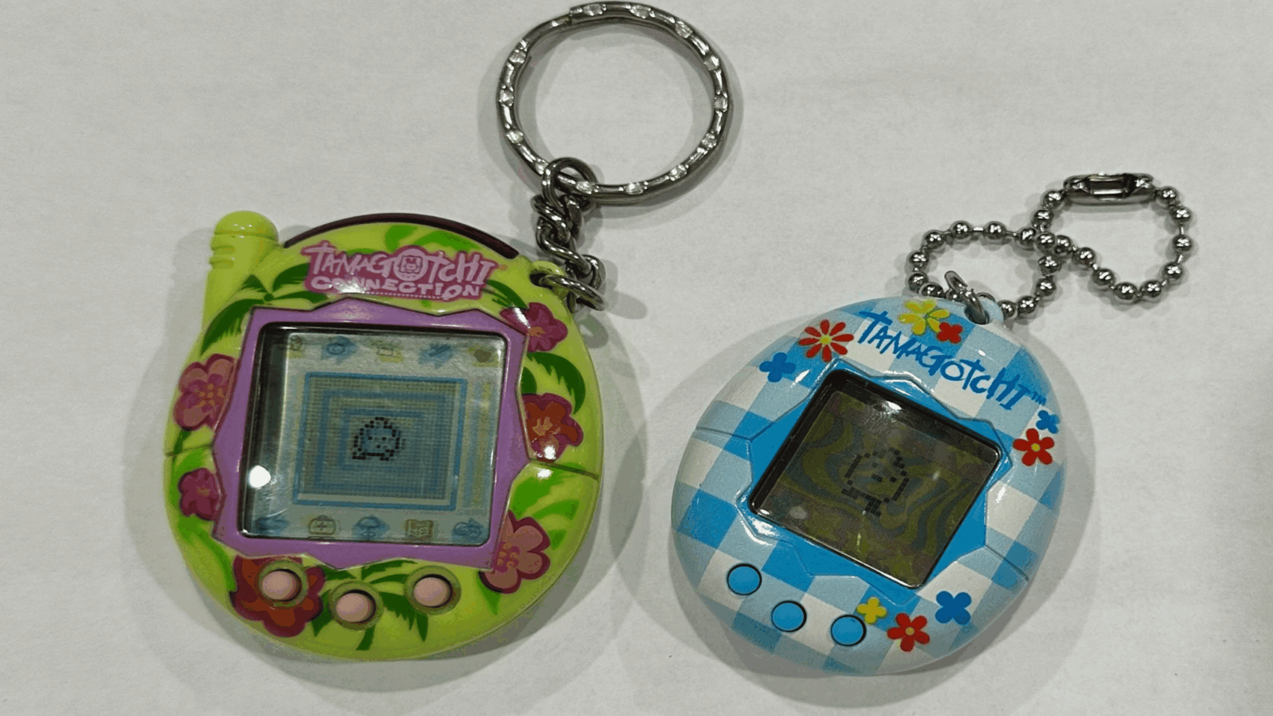 two tamagotchis, one green, one blue.