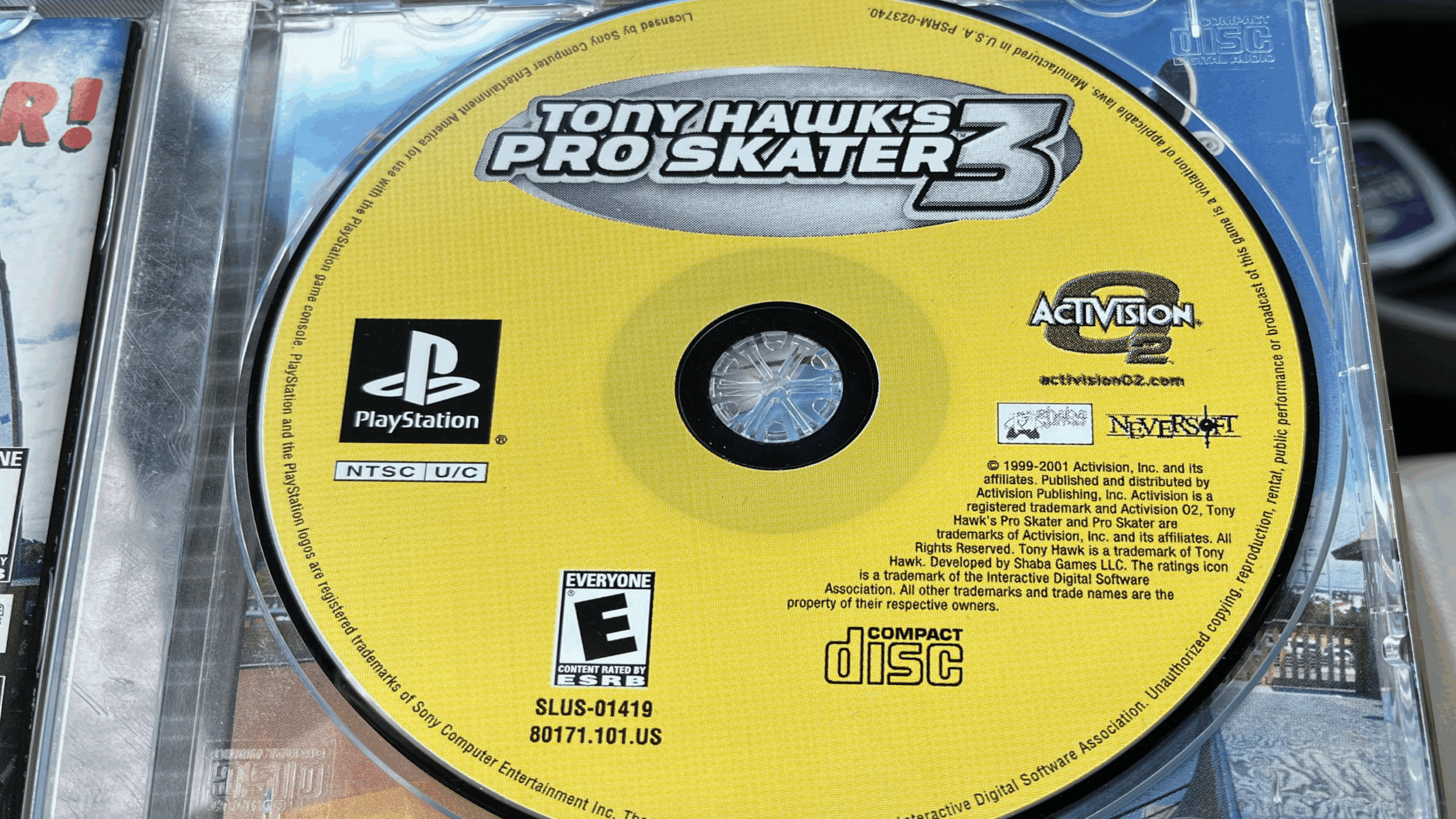 A close-up of the yellow “Tony Hawk’s Pro Skater 3” PlayStation Game Disc inside its case, showing logos for PlayStation, Activision, Neversoft, and the ESRB rating “E” for Everyone.